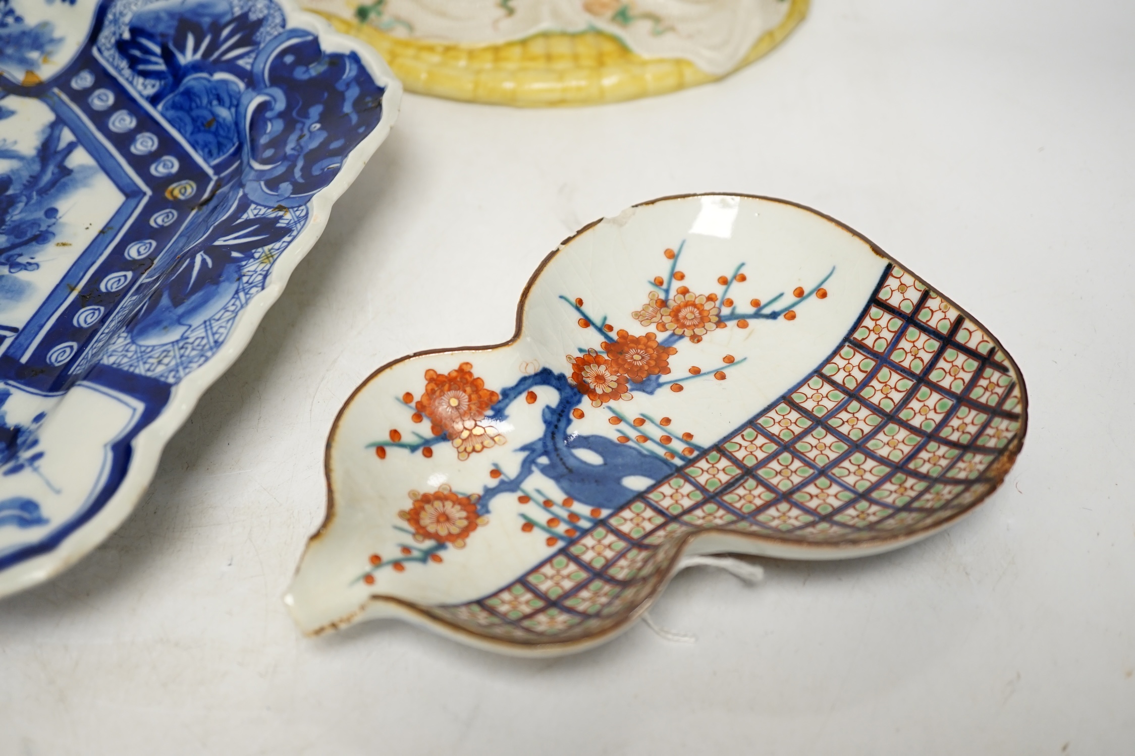 A Japanese seated porcelain figure of Kwannon, an Imari dish and a kakiemon style dish, largest 35cm diameter (3). Condition - blue dish good, others poor to fair